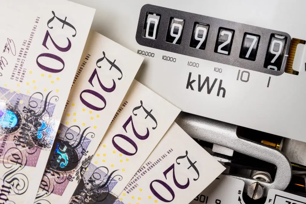 Electricity meter and cash notes, concept for meter reading, energy bills, price rise, inflation and fuel.