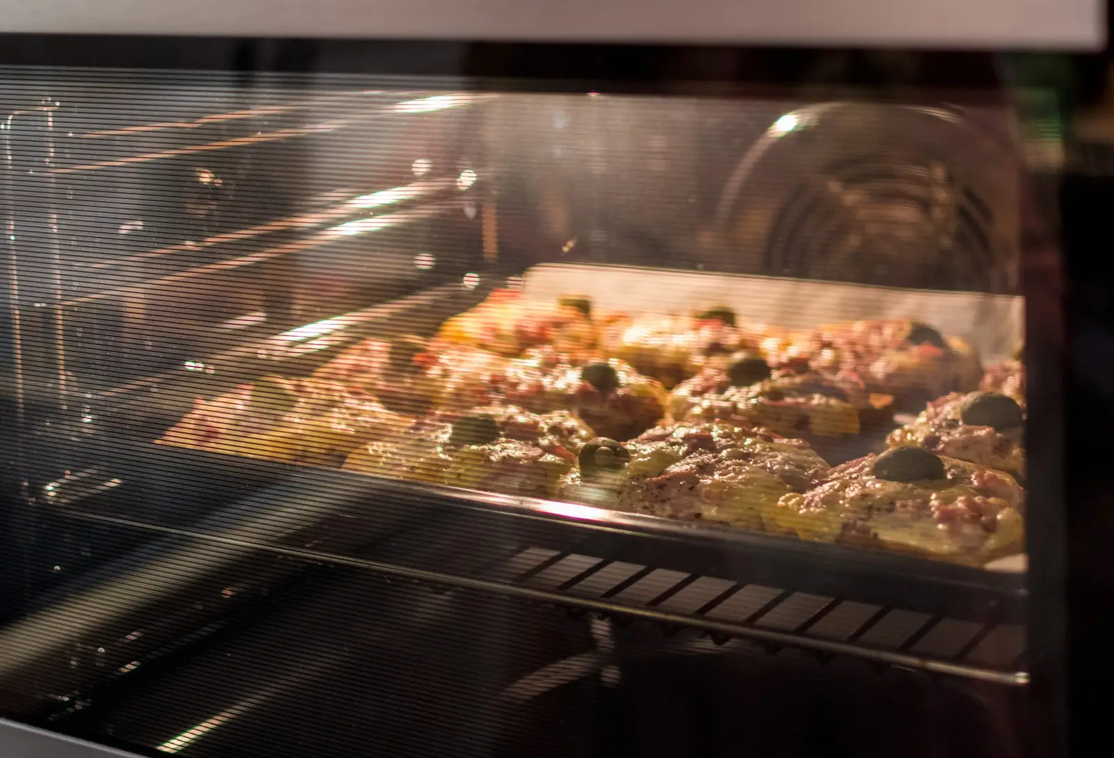 Mini pizzas baking in a hot oven — a properly preheated oven reaches temperature in 10 to 15 minutes and maintains it evenly throughout cooking