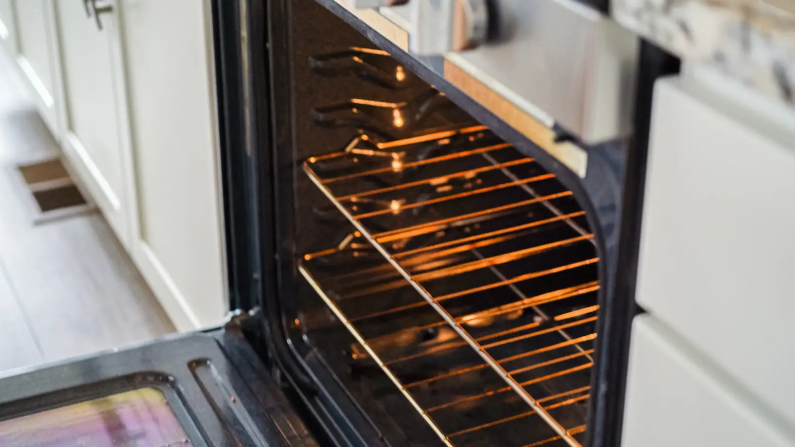 Open oven door in a clean modern kitchen — ready for a burn-in cycle before first use