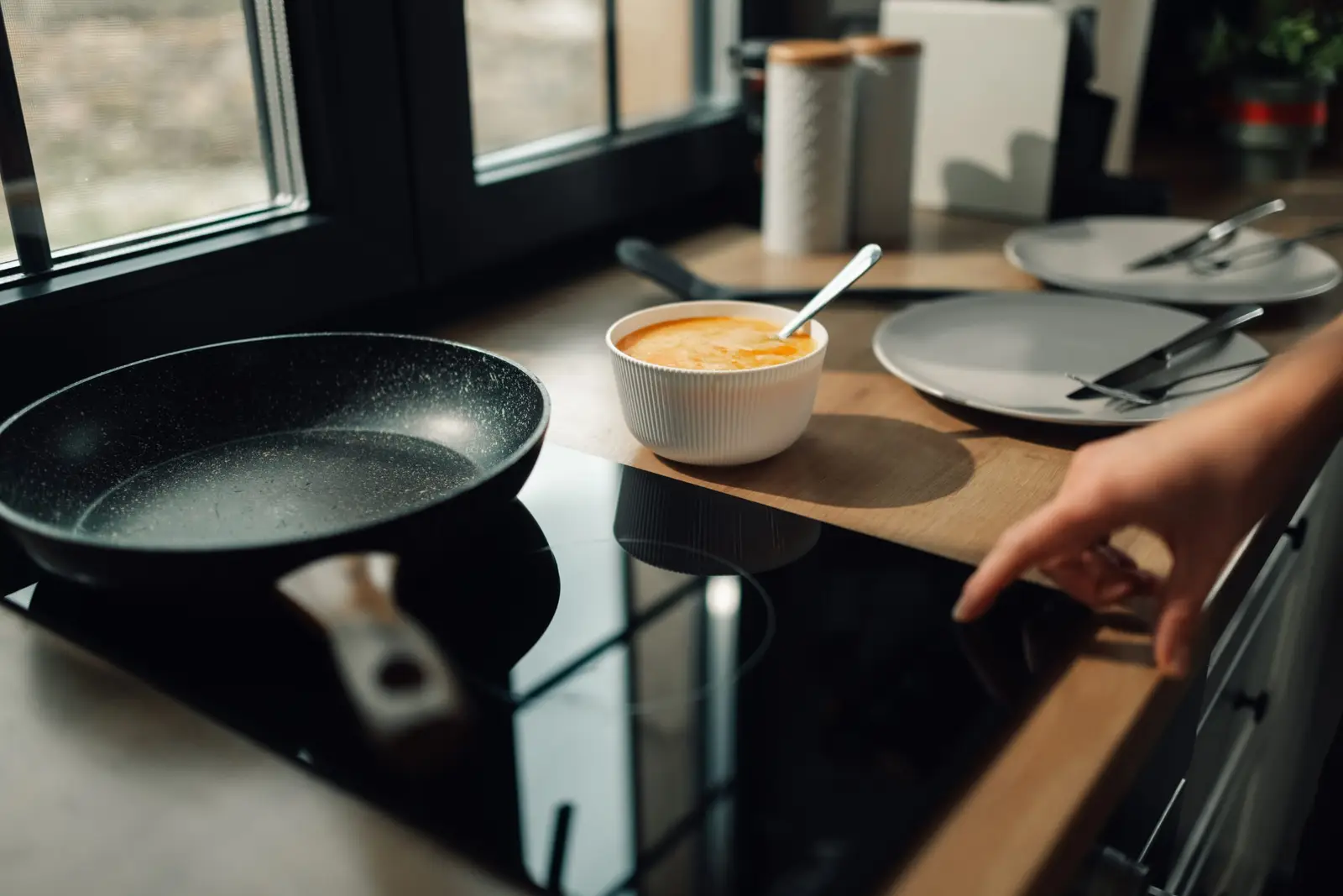 Person preparing food on an induction hob in a modern kitchen