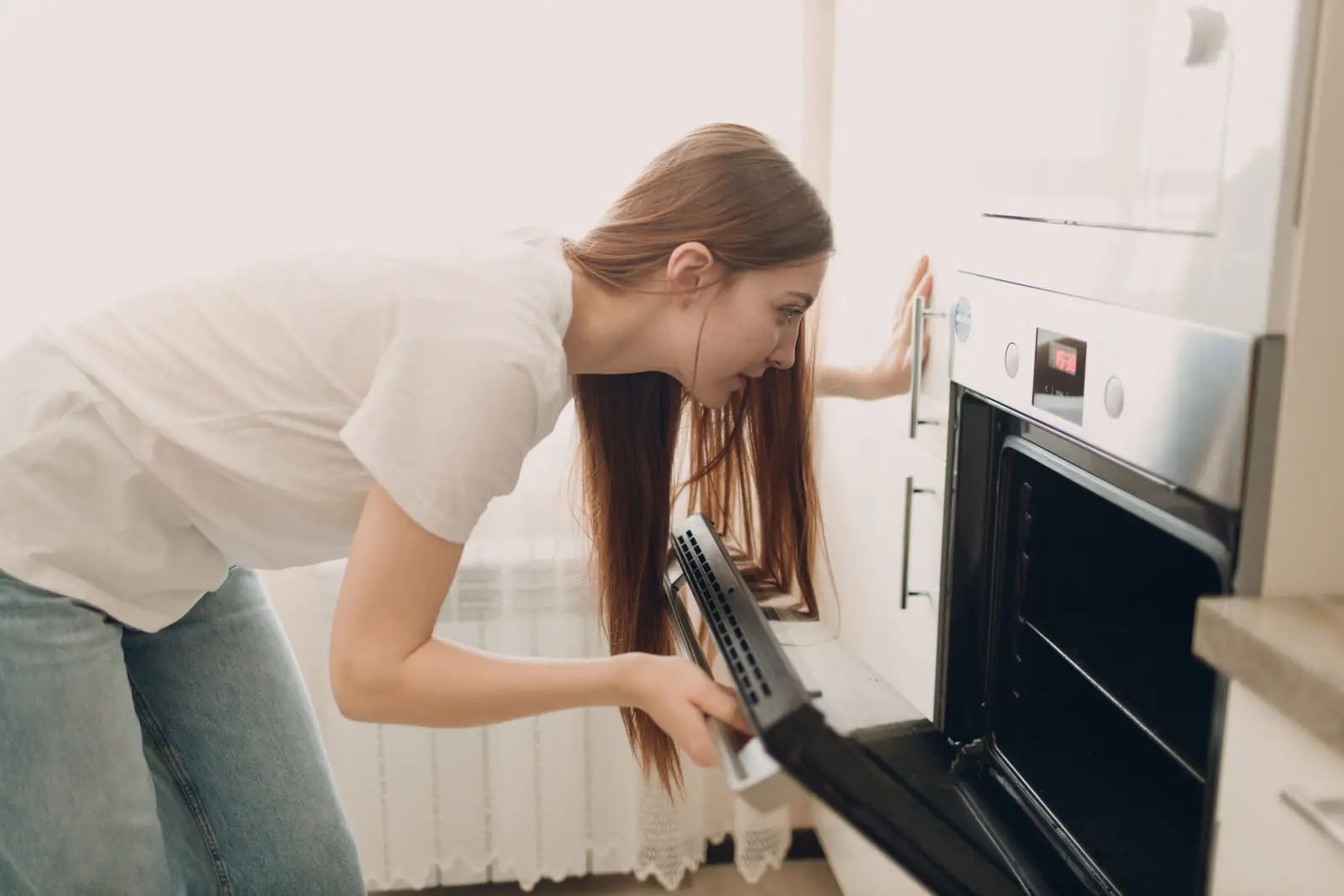 Woman preparing food in a modern kitchen — oven smells on first use are common and almost always harmless