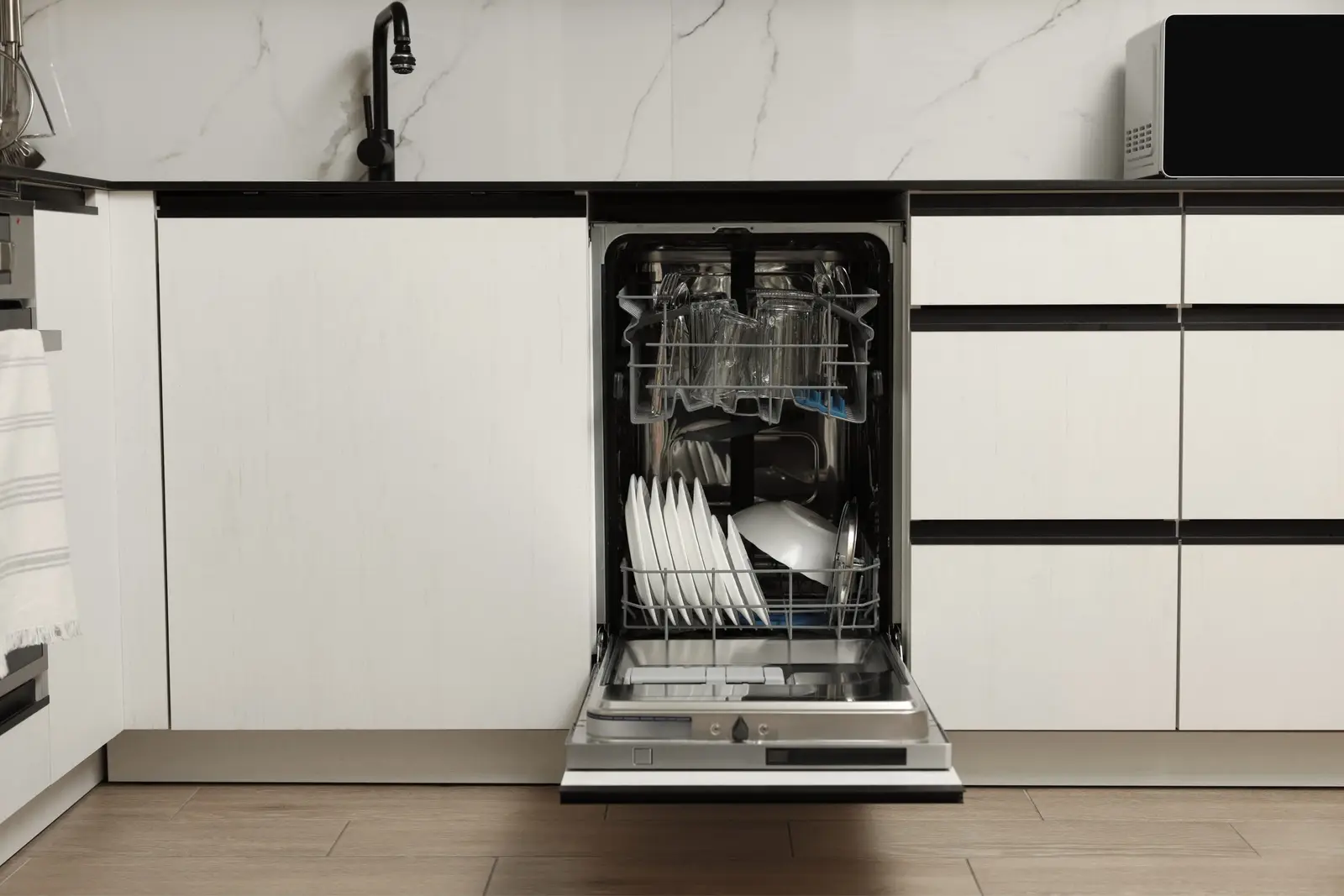 Clean modern kitchen with an open integrated dishwasher