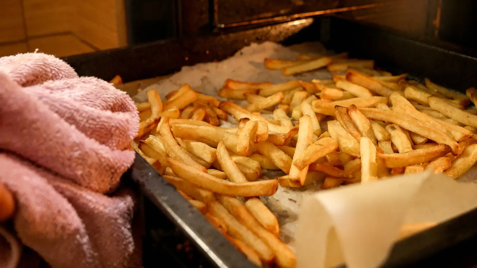 Crispy oven baked chips spread across a tray fresh from the oven