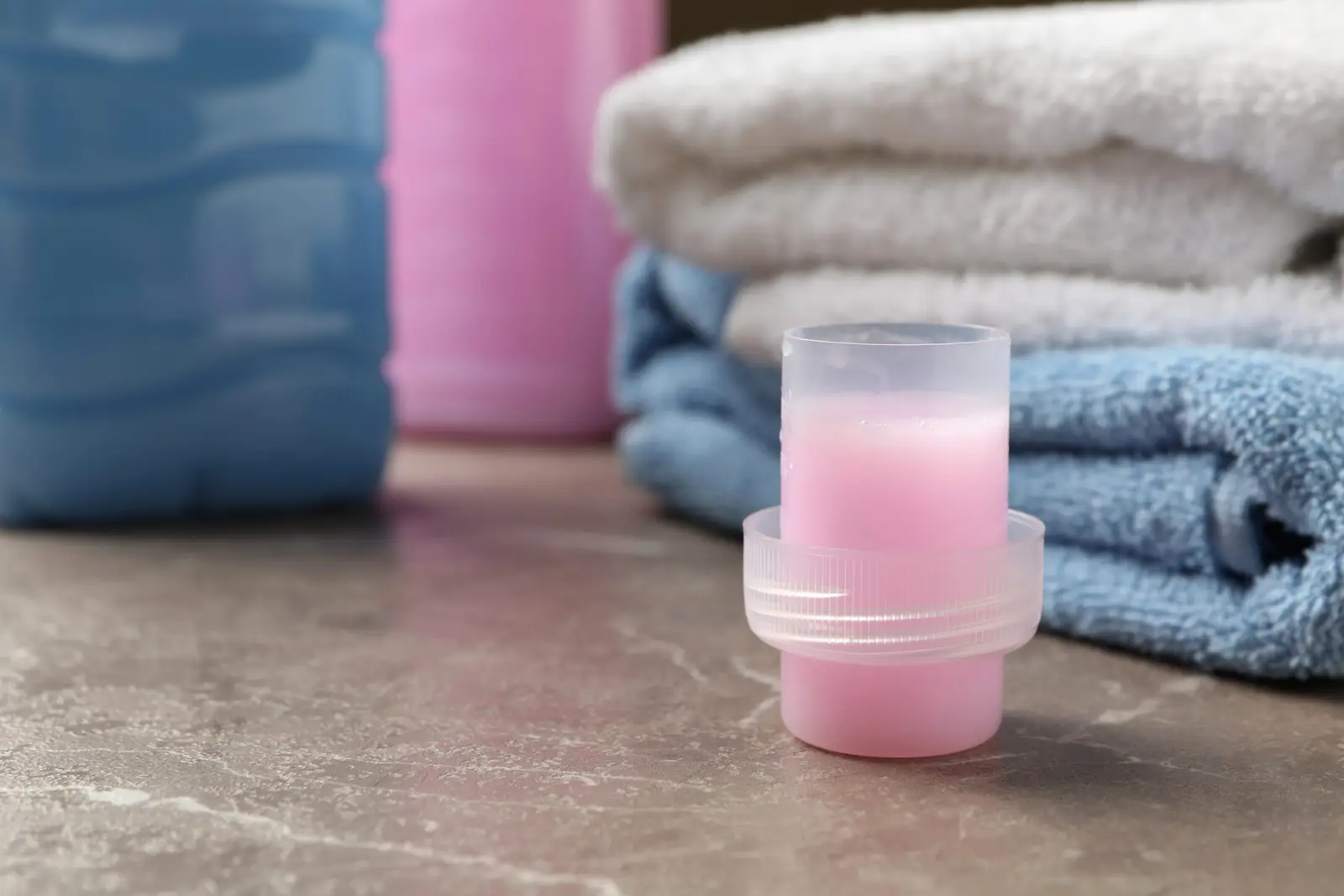Folded fresh towels next to laundry detergent