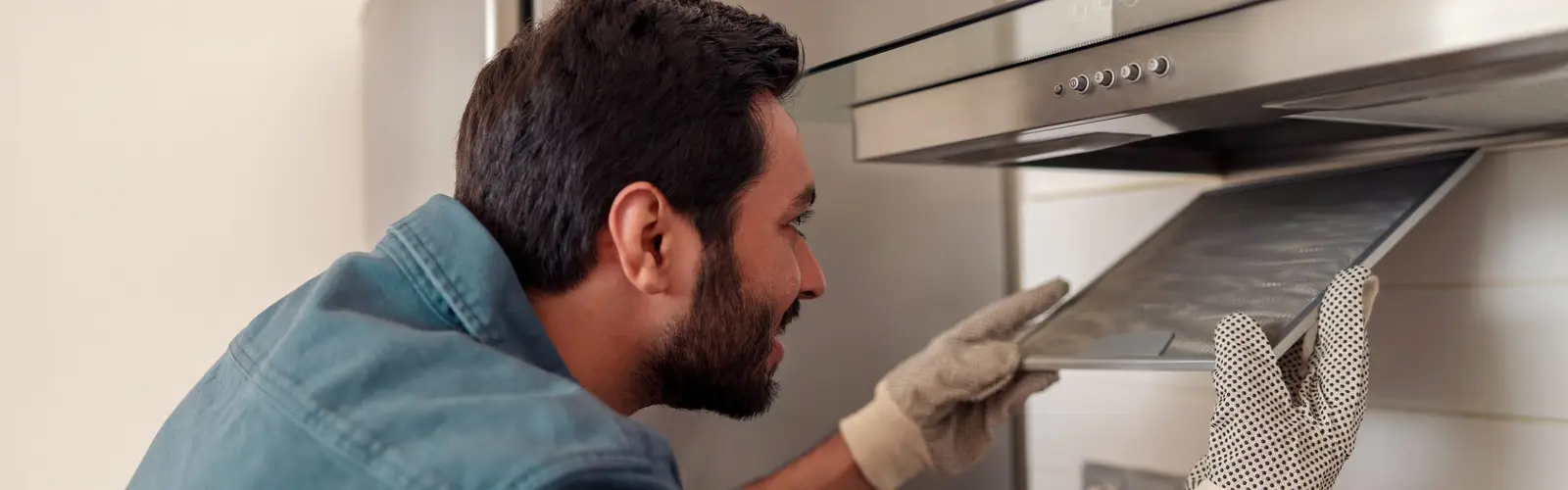 Person replacing the filter in a kitchen cooker hood extractor fan