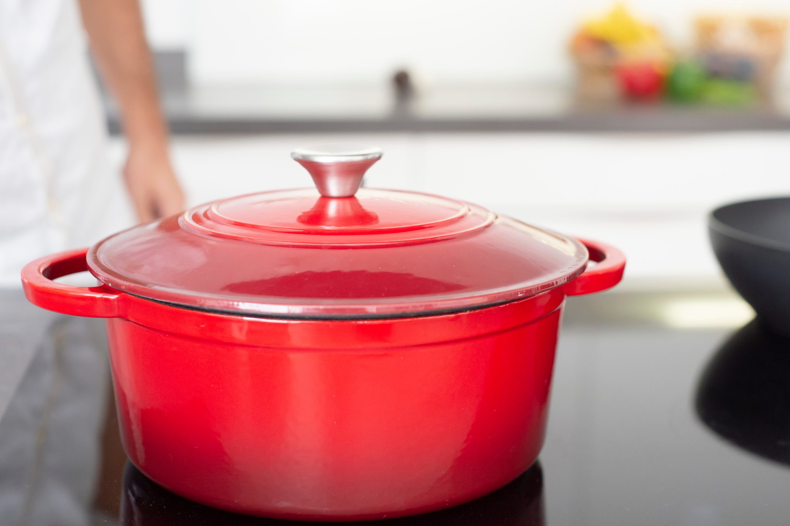 Red enamelled cast iron Dutch oven in a bright modern kitchen